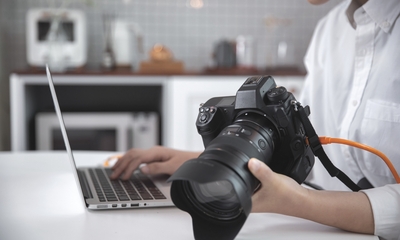 Female photographer editing photos on laptop
